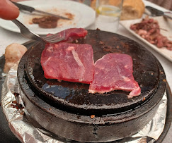 Carne roja cocinandose en piedra caliente