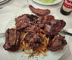 Costillas asadas servidas con patatas